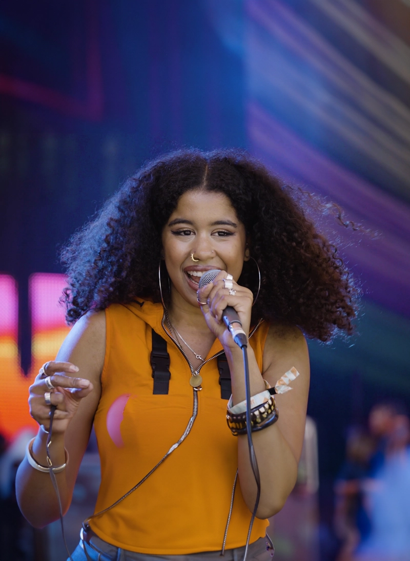 Image of artist with mic on stage at festival
