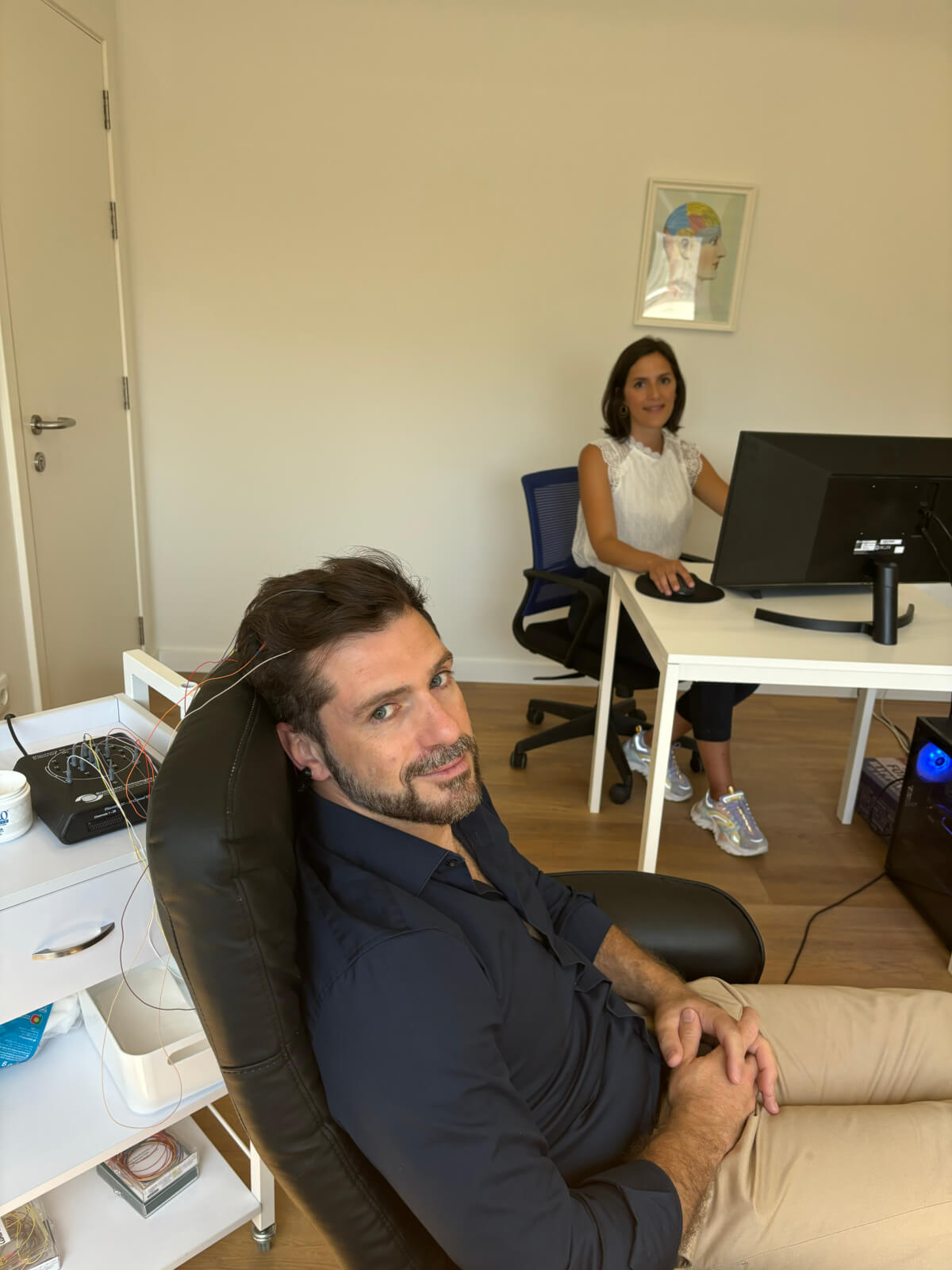 Paciente sentado em porltrona enquanto realizar testes perante especialista.