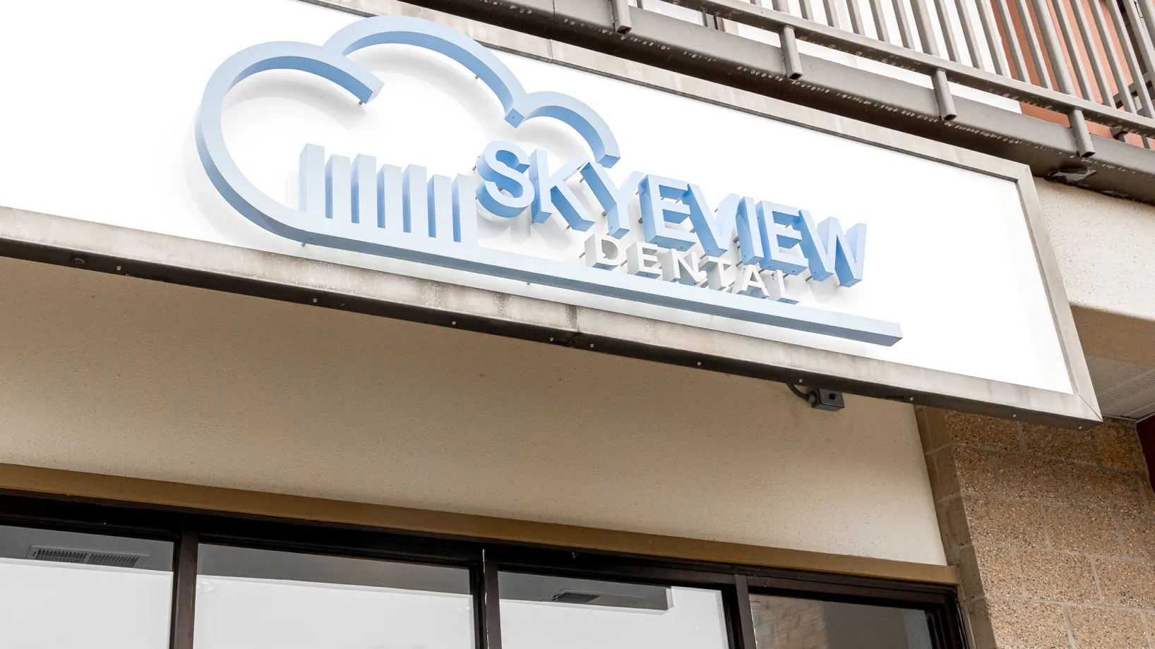 A sign on the side of a building for a dental office.