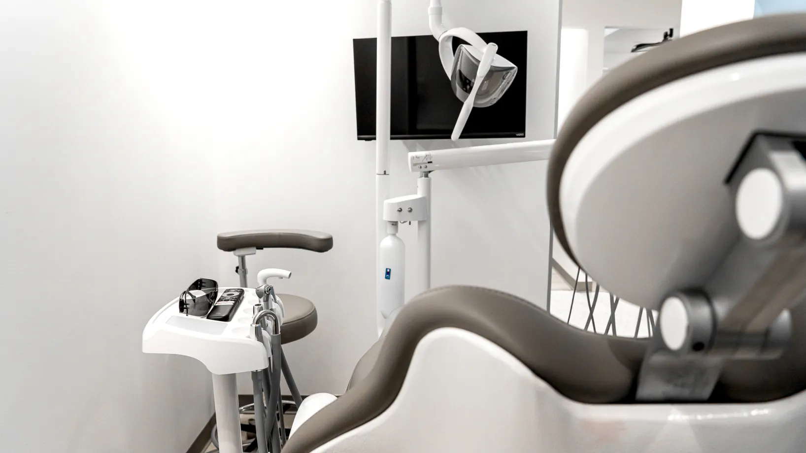 A dental room with a chair and other medical equipment.