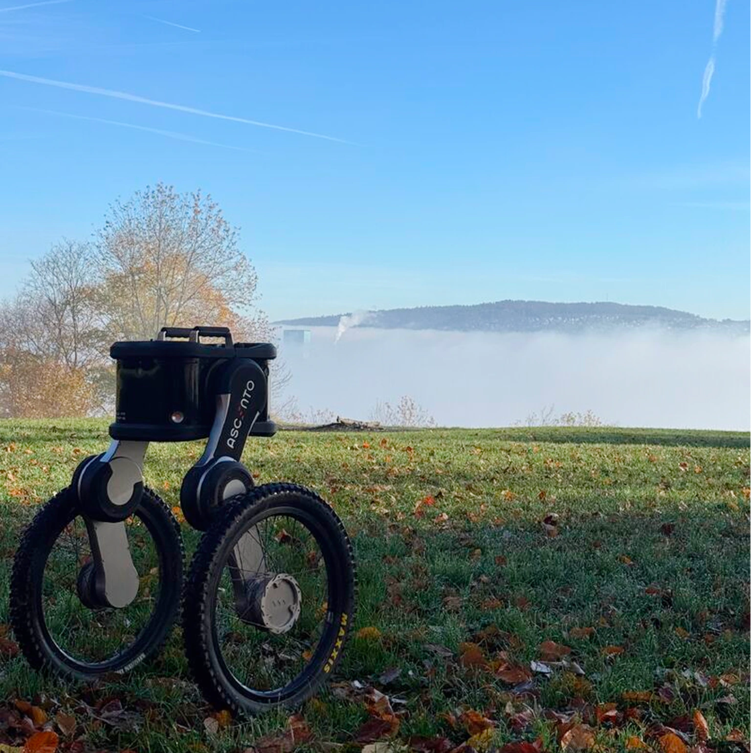 Ascento Guard security robot patrolling uneven outdoor terrain in foggy conditions.