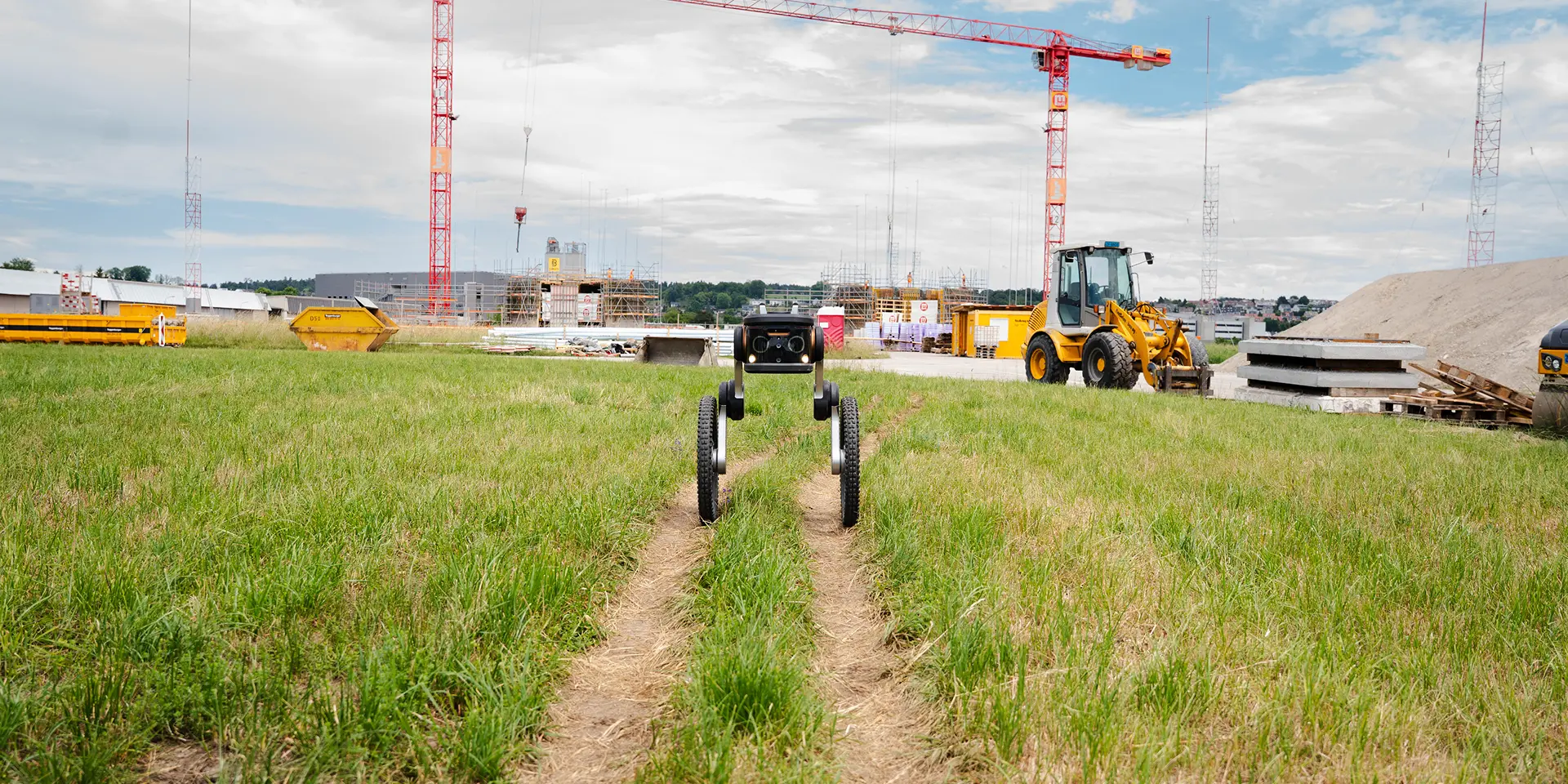 Ascento Guard security robot autonomously patrolling rough terrain at a construction site.