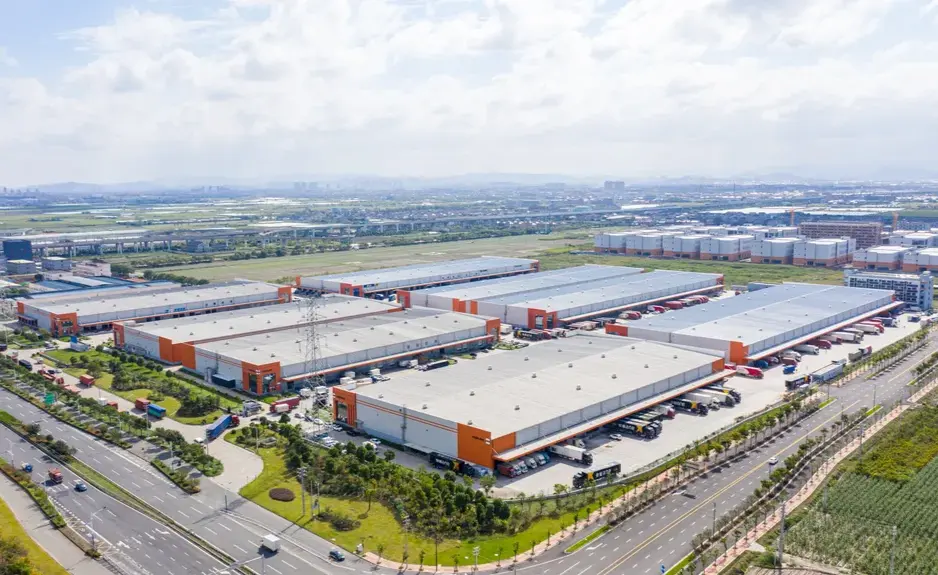 Aerial view of a large industrial logistics complex with warehouses, loading docks, roads, and surrounding infrastructure.