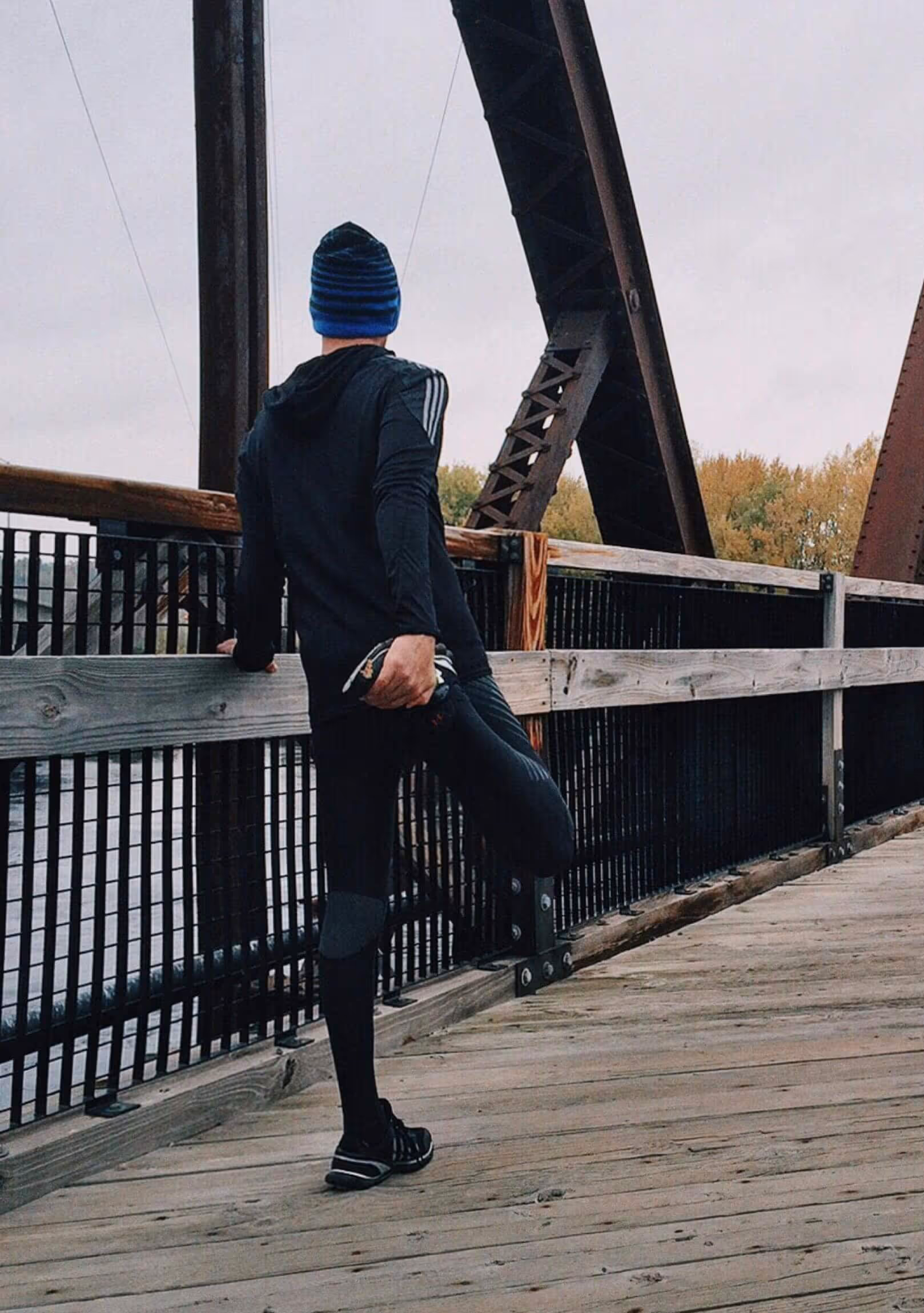 Person stretching on a bridge in cool weather, showing how physical activity supports brain health