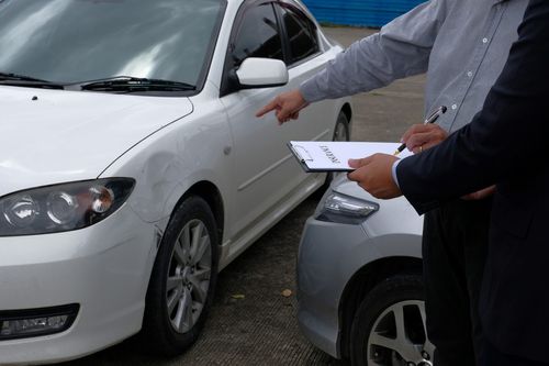 loss adjuster inspecting a damaged car