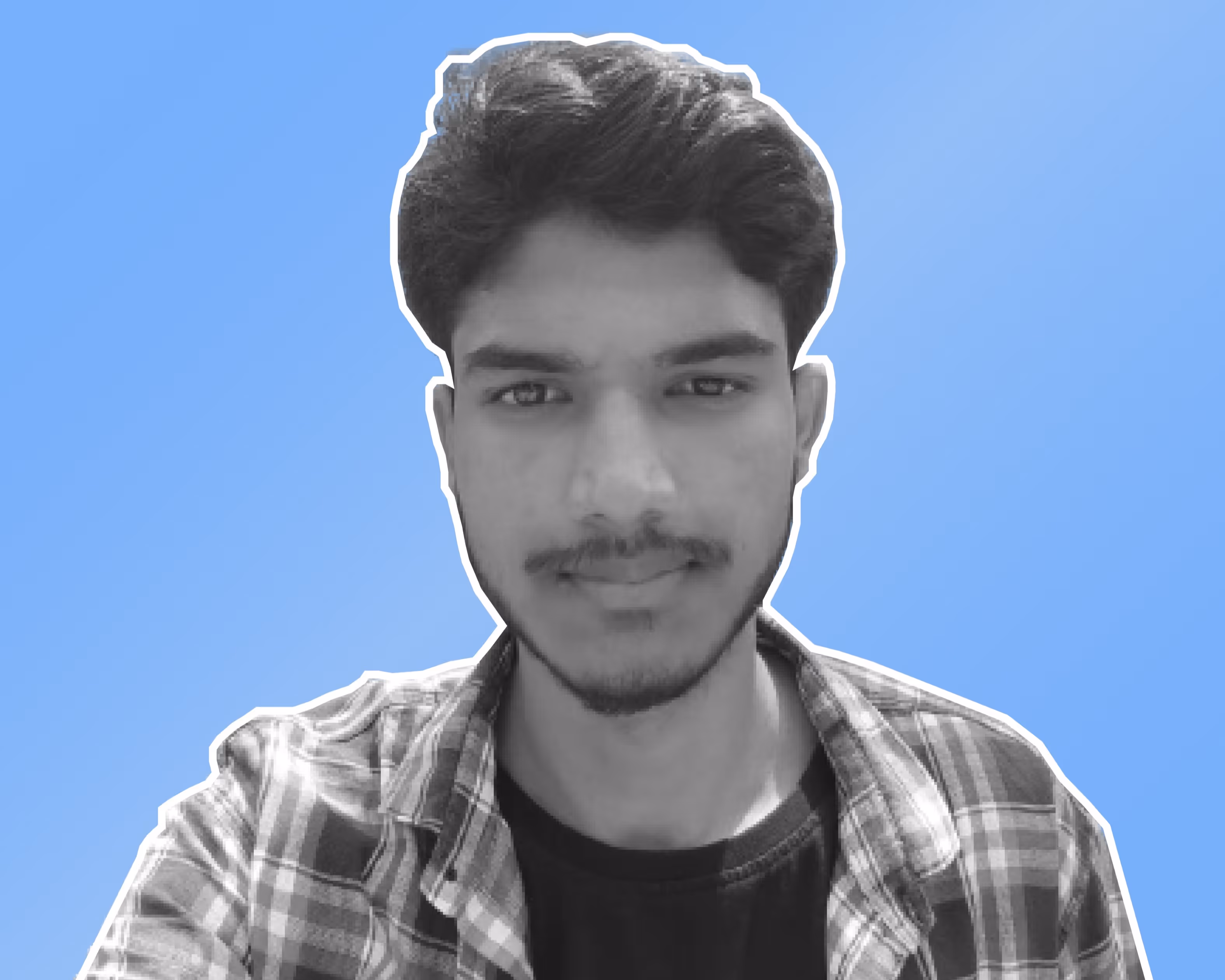 Young man with short hair and beard wearing a checkered shirt over a black t-shirt on a blue background.