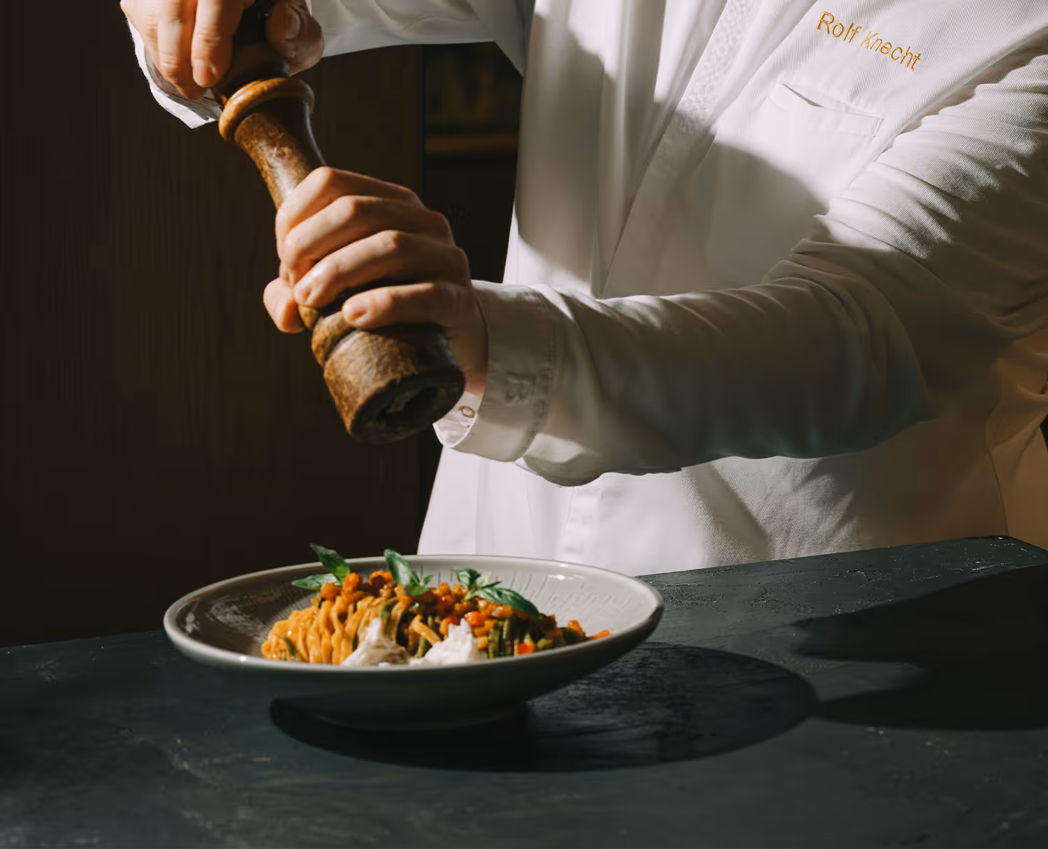 Chef peppers a dish from the Delta restaurant