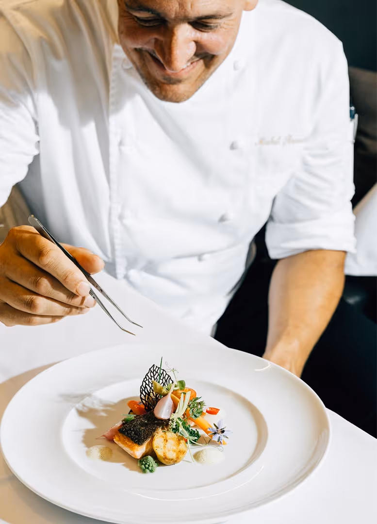 Koch dekoriert ein Gericht für das Hotelrestaurant des Deltapark Vitalresort am Thunersee