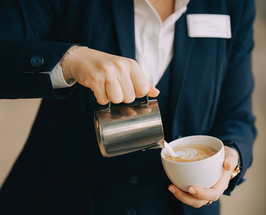 Restaurant specialist as barista makes cappuccino 