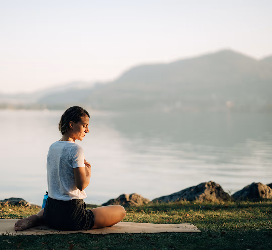 Dame in Yogapose direkt am Ufer des Thunersees beim Deltapark Vitalresort