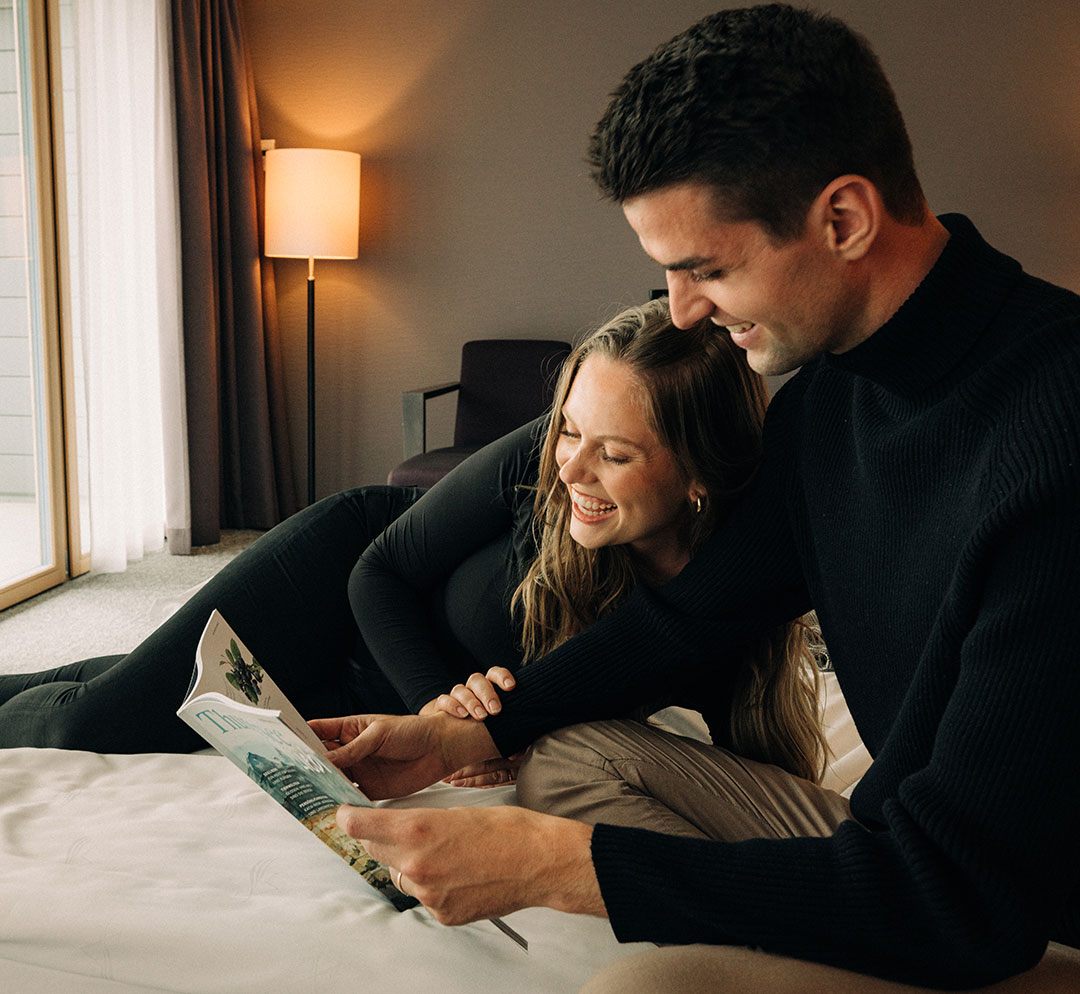 Ein Paar liest zusammen eine Zeitschrift im Hotelzimmer