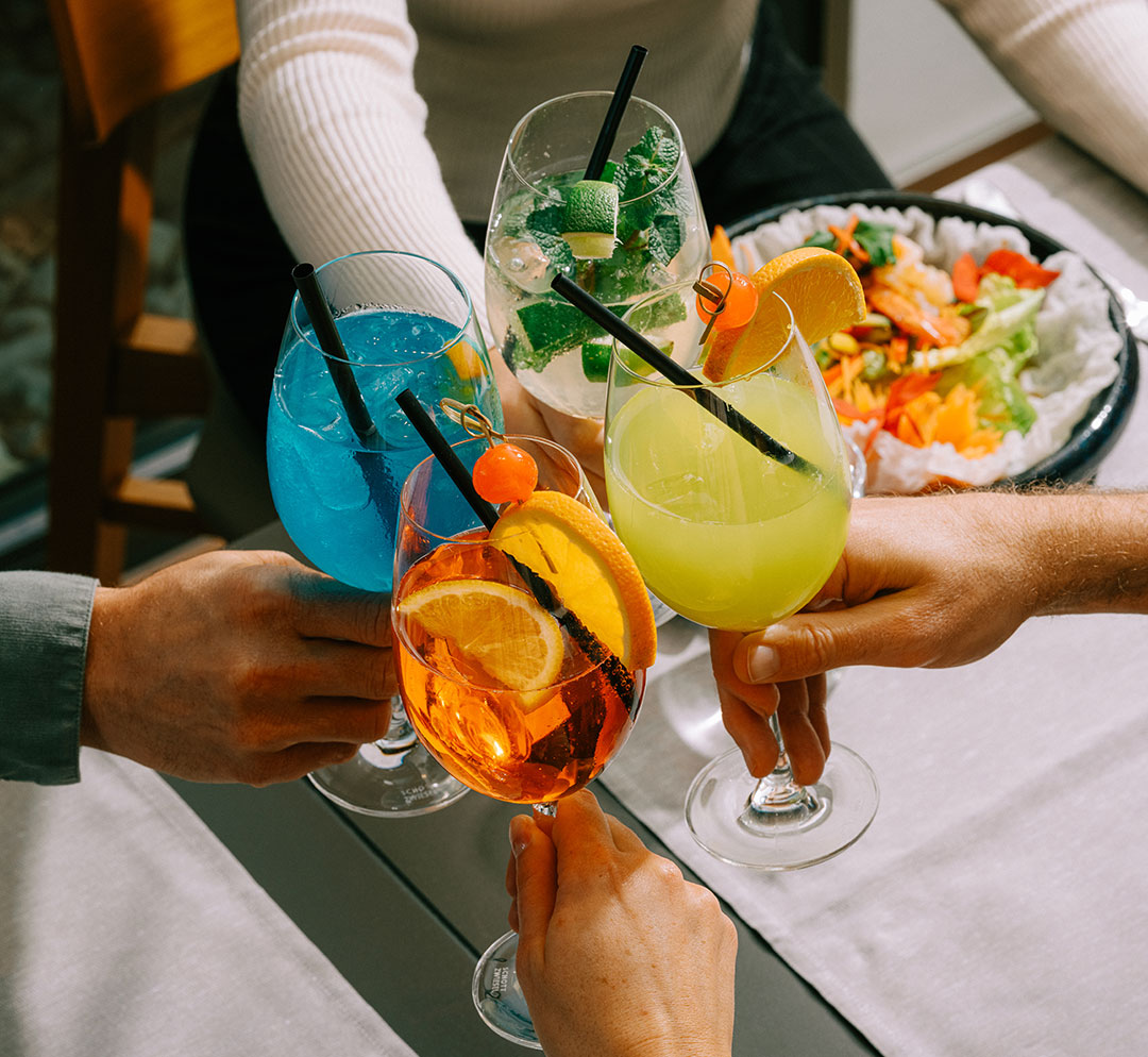 4 Personen stossen mit Cocktails im Restaurant Deltaverde Thai Cuisine an