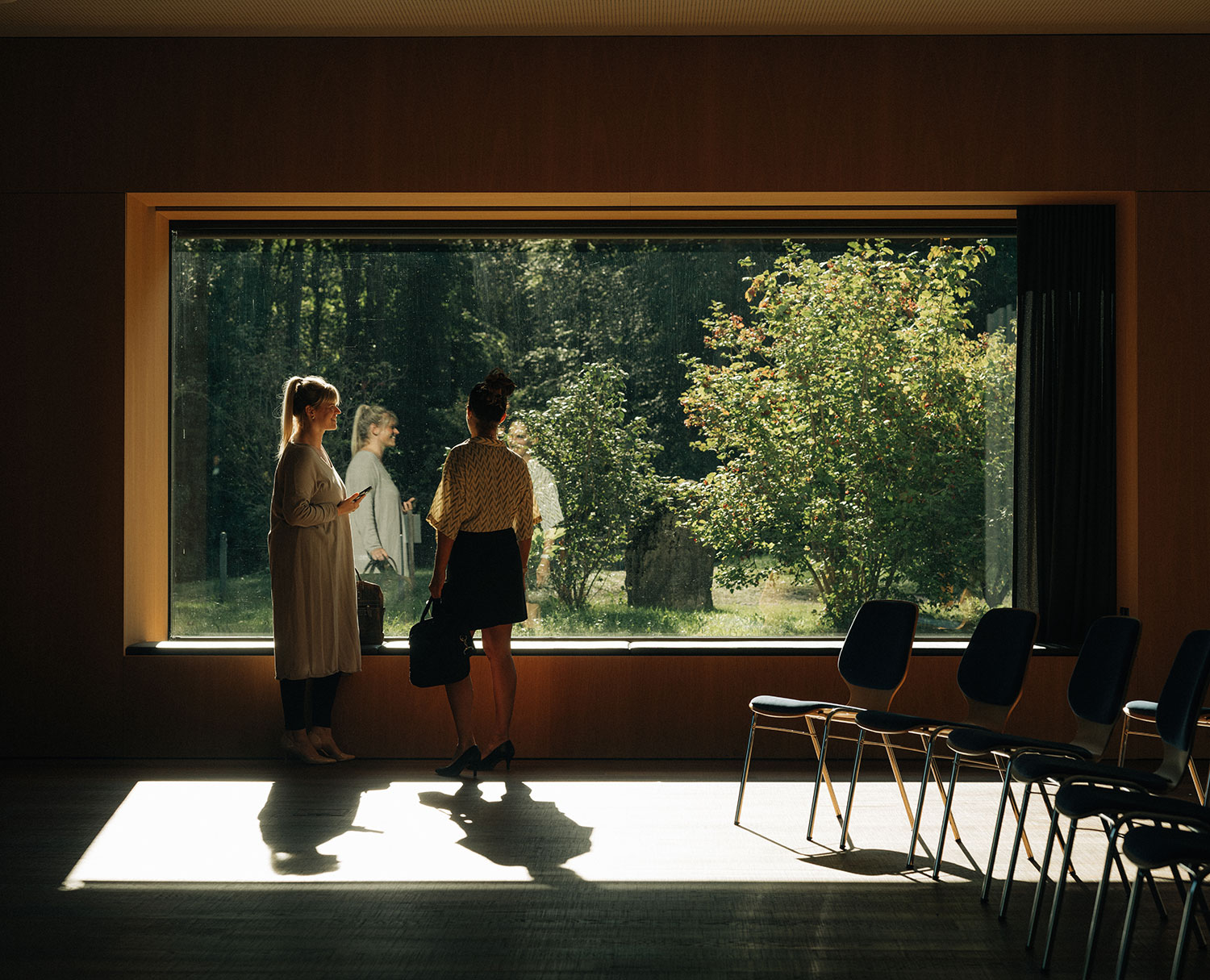The Kander seminar room in the main building of the Deltapark Vitalresort, featuring a large window overlooking the forest