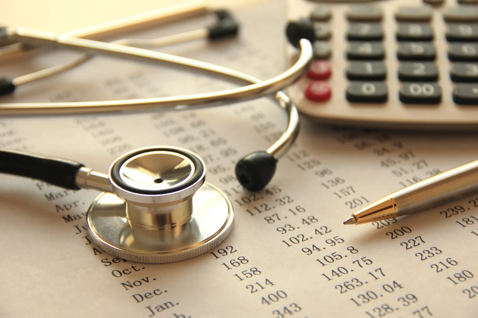 Stethoscope, pen and calculator resting on a printed billing ledger
