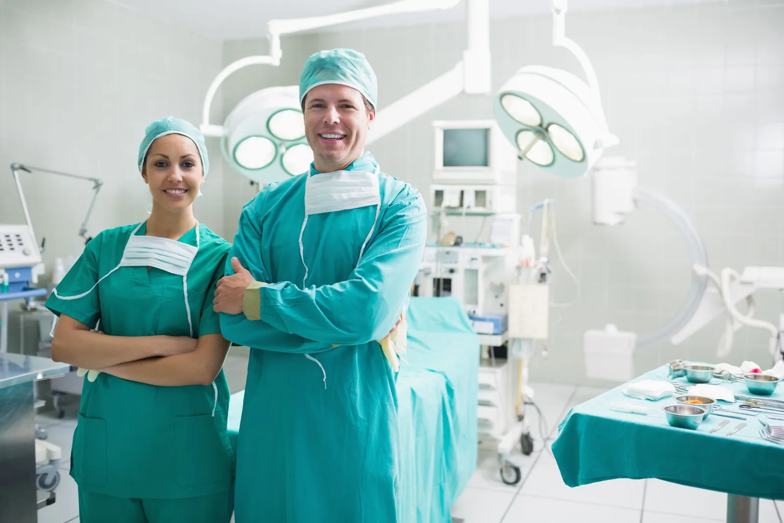 Two surgeons in green scrubs standing in an operating room
