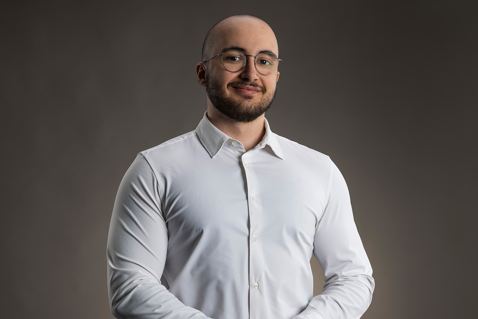 Mihail Efremov in a white shirt against a gray background.