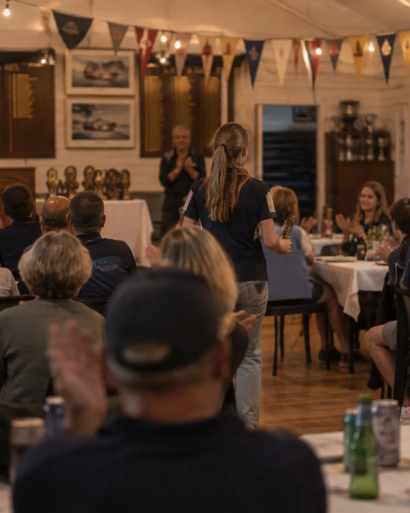 A country club presentation night, a girl walking back to her table with a trophy
