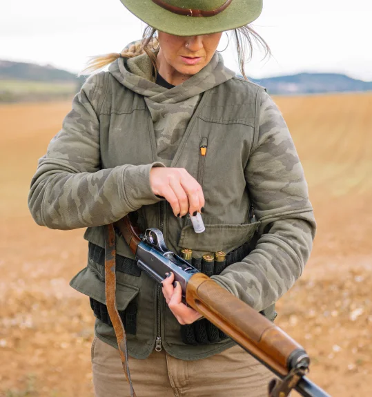 Woman with shotgun at shooting range — SquadSpot data-driven compliance reporting