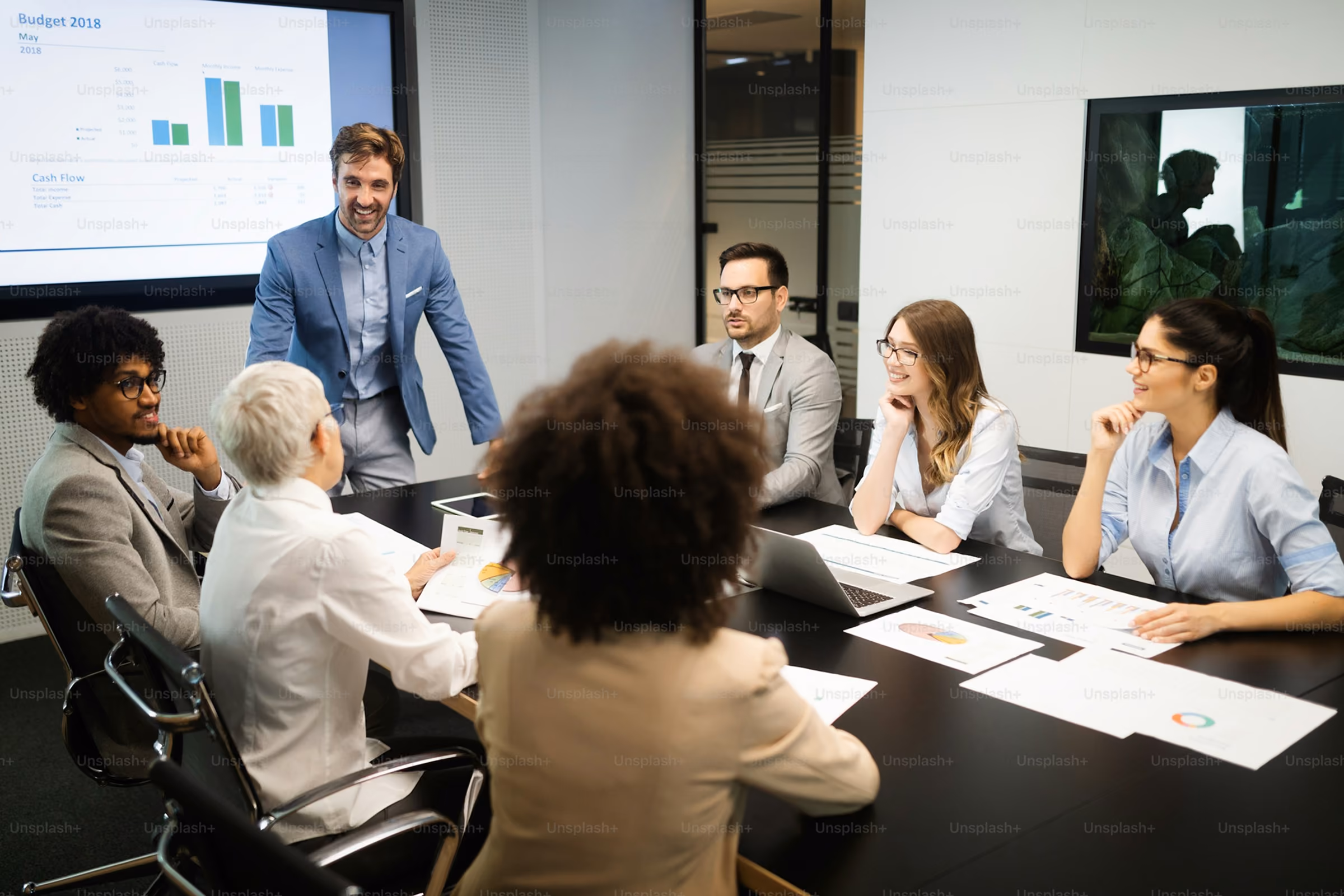 Business team discussing financial charts and budget data in a modern conference room.