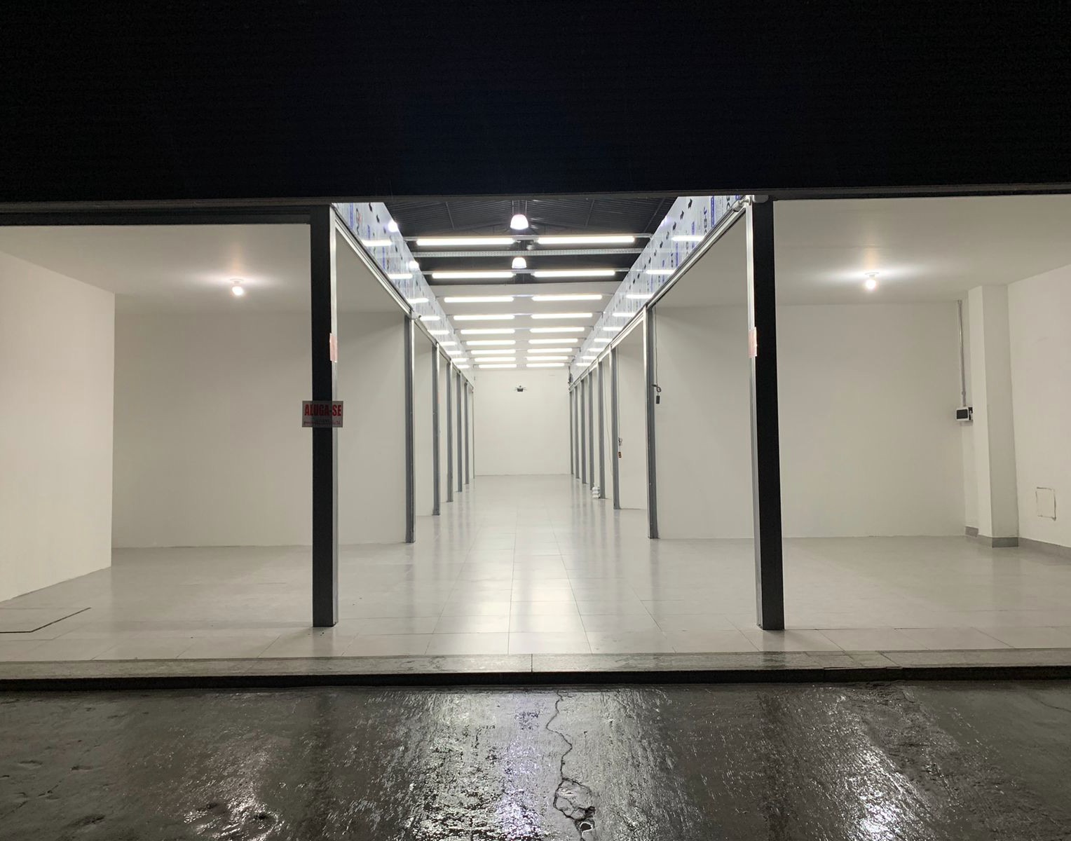 Corredor da Galeria 455 com os boxes vazios e iluminados