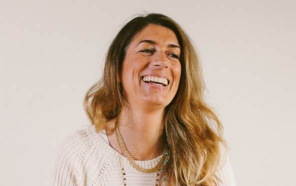Smiling woman wearing a knit sweater and gold necklace