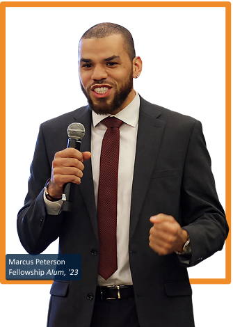 Man in suit and tie holding a microphone making a speech- The Fellowship Images