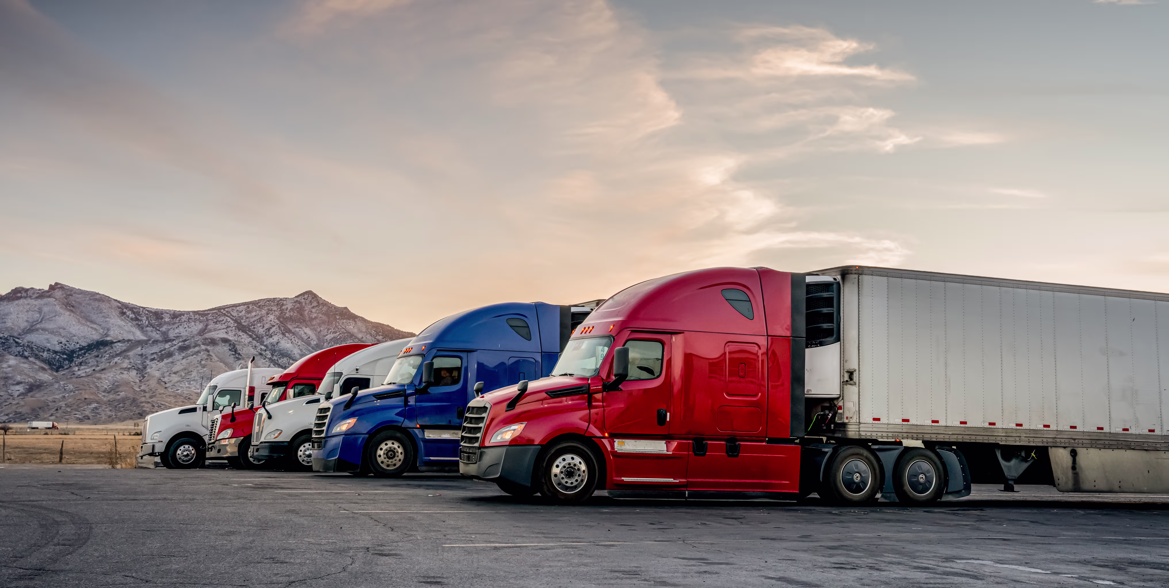Semi trucks in the foreground and mountains in the background