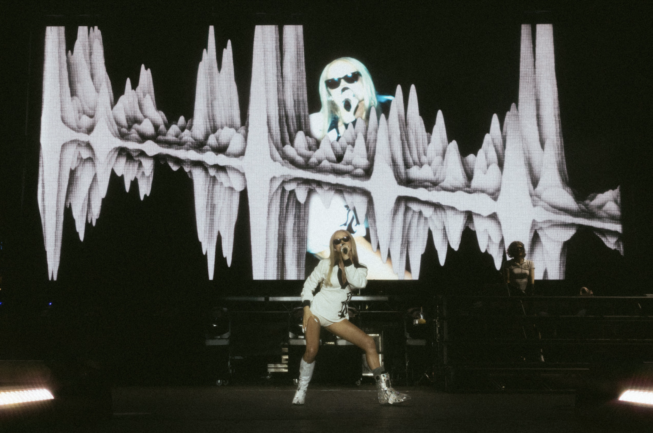 Kim Petras performing in front of Raw Cereal screen content at a Pride festival
