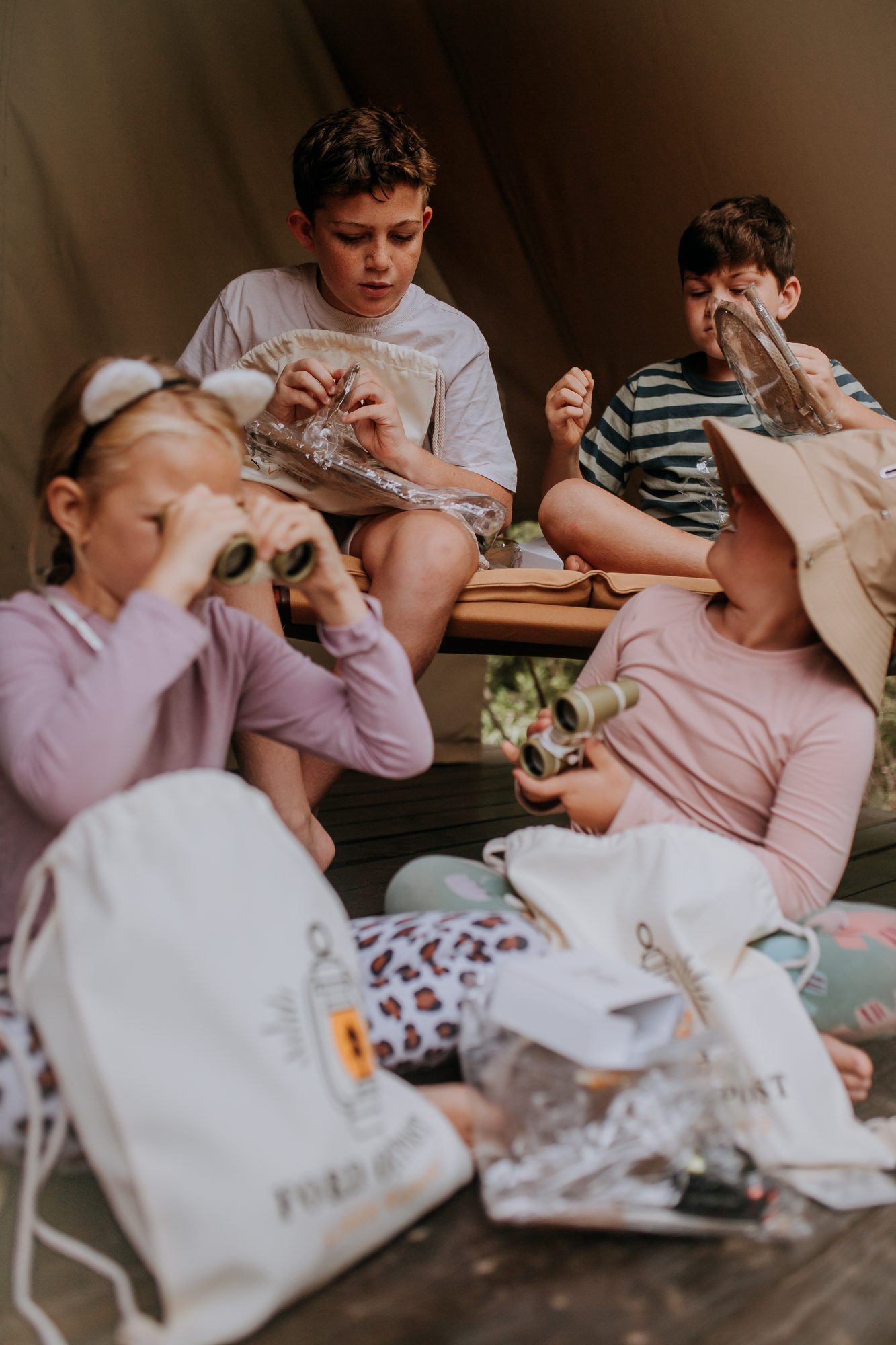 Children unpacking their Little Explorers Bug Bags, binoculars in hand