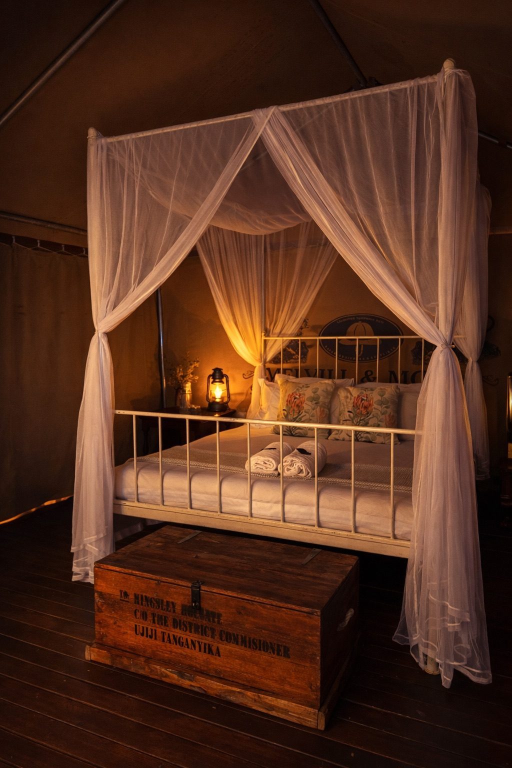 Tent 1, a double bed under a mosquito net lit by a lantern