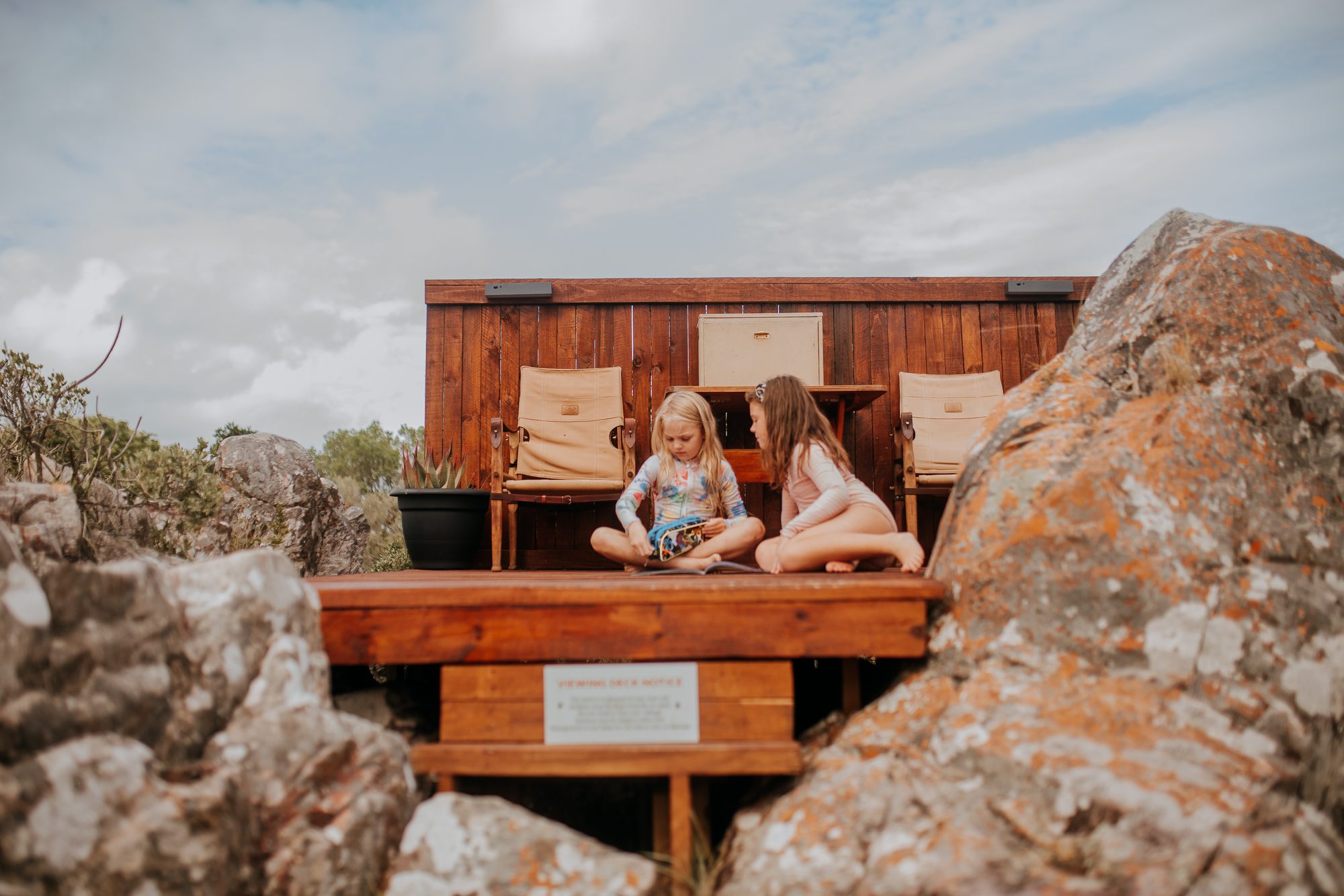 Two girls reading on the timber viewing deck among the rocks