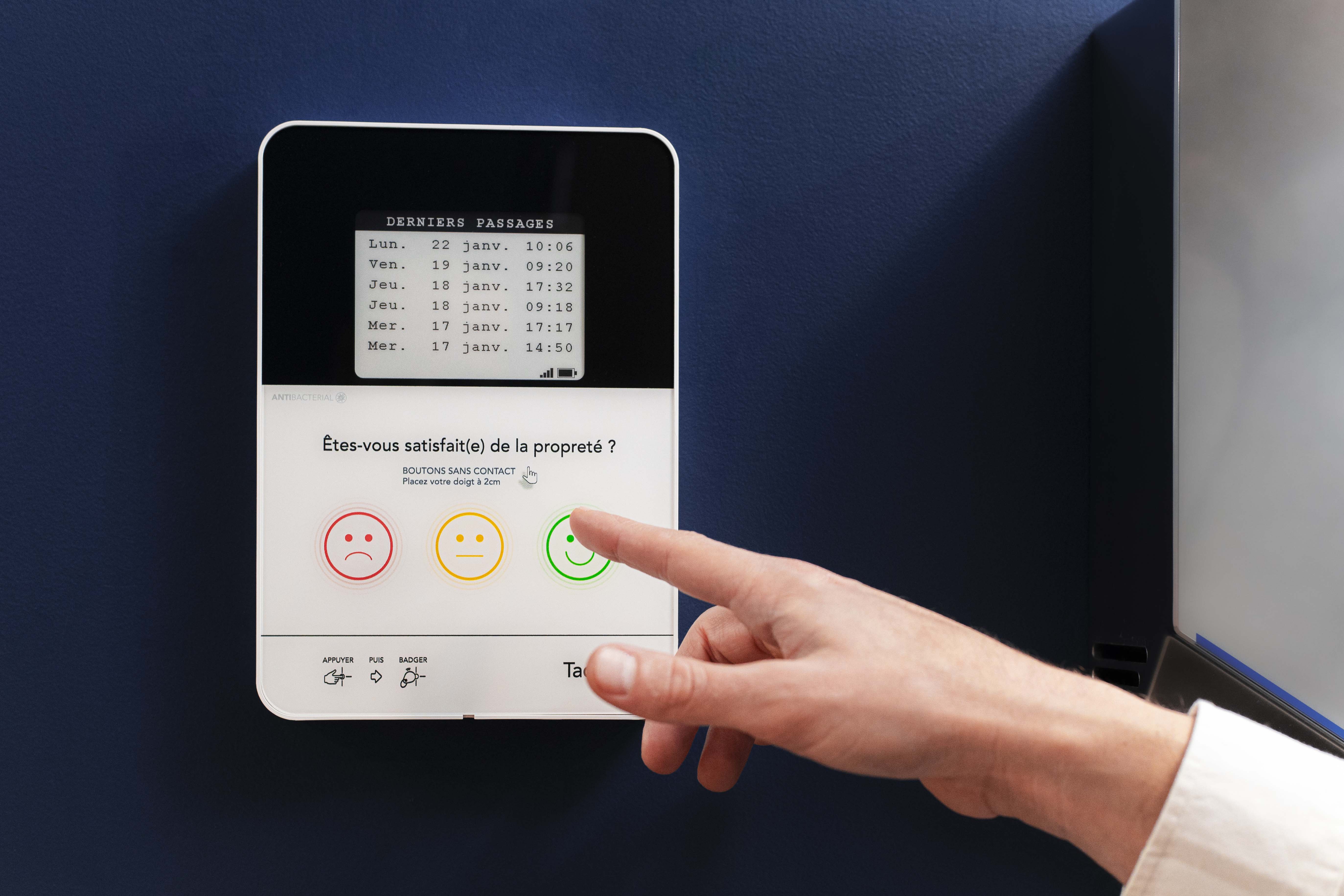 Un client donne son avis sur une borne de satisfaction Smiley