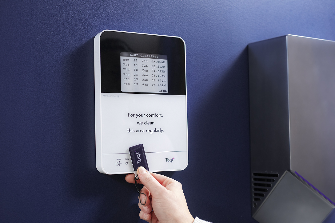 An employee clocking in on a TaqtOne, a time-tracking device