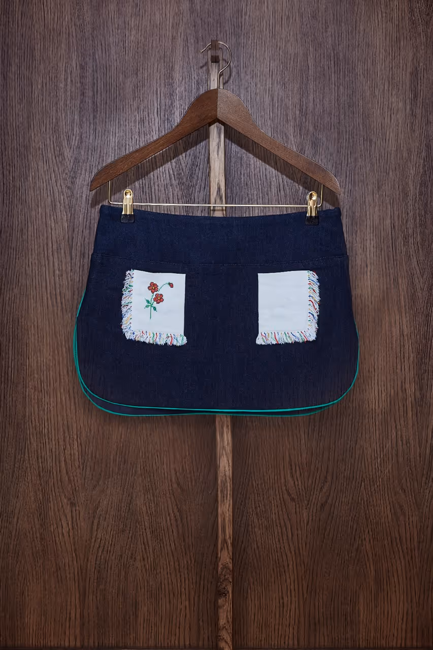 Mini skirt in lined denim, low waist marked by a denim panel, rounded side slits with piping finishes, invisible side zipper, pockets made out of lined vintage embroidered napkin. Denim : 98% cotton - 2% lycra Napkin : 100% cottonLining : 100% cottonDry Cleaning Only.Made in South of France.The embroidered napkin is a unique piece.