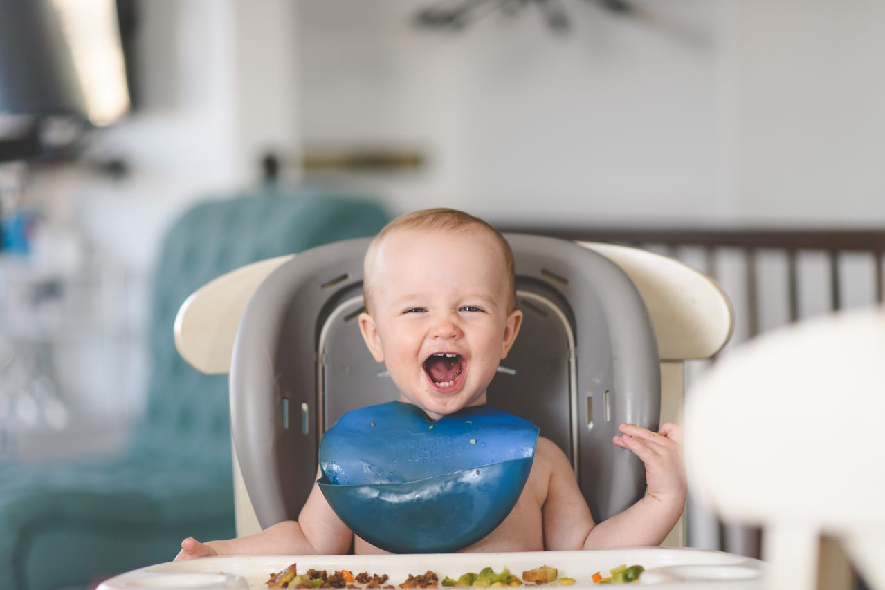 Infant eating and smiling