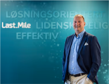 Hans-Jürgen Solly is standing by a wall covered with banners