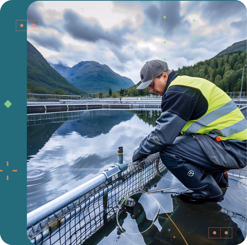 Worker in reflective vest and cap inspecting a fish farm tank with mountains and forest in the background.