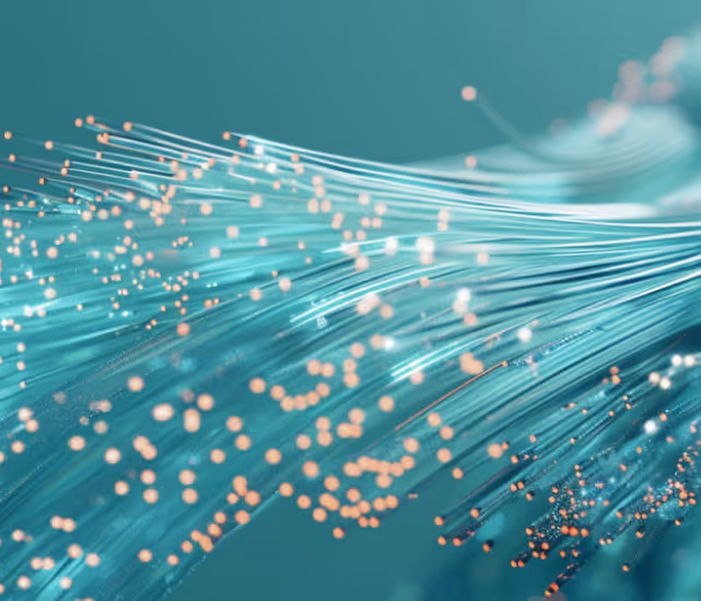 Close-up of glowing fiber optic strands with orange and white light points on a teal background.