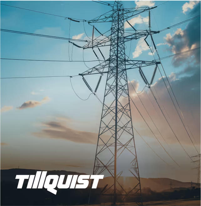 Electricity transmission tower with power lines against a cloudy sky at sunset.
