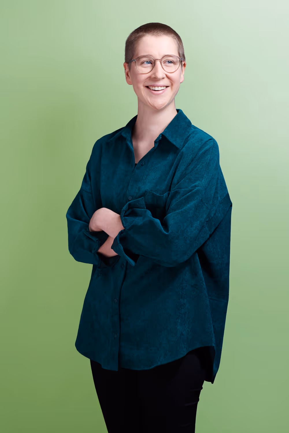 Die Mitarbeiterin von Jusonline Dina Bütschi steht mit verschränkten Armen vor farbigem Studiohintergrund.