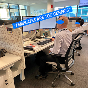 A photo of two men looking at their monitors while working in front of their computers at their desks.