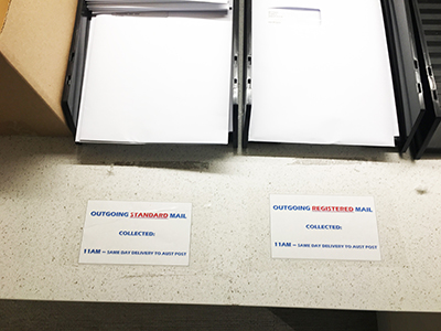 Photo of two office trays: one for outgoing standard mail and the other for outgoing registered mail.