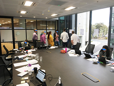 A photo of a group of people looking at persona's artefact placed on a window.