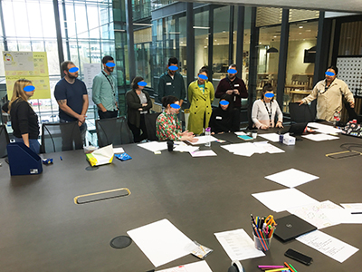 A photo of a woman presenting to an audience, the user flow her team developed. 