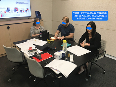 A photo of a woman testing a paper prototype while two other people take notes.