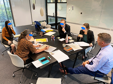 A photo of people discussing and taking notes in an office.