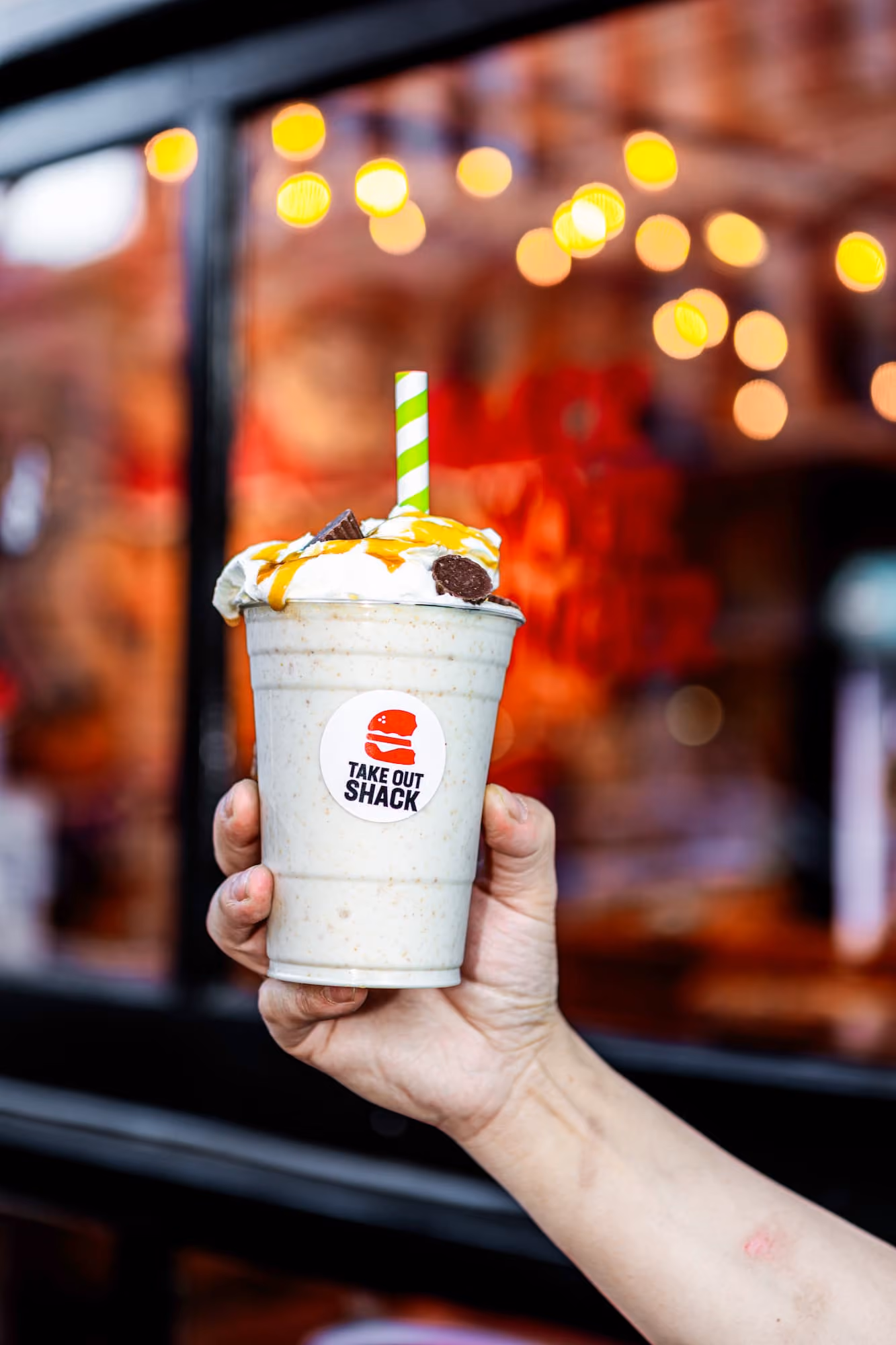 Person holding a milkshake in front of Take Out Shack in Vancouver, BC