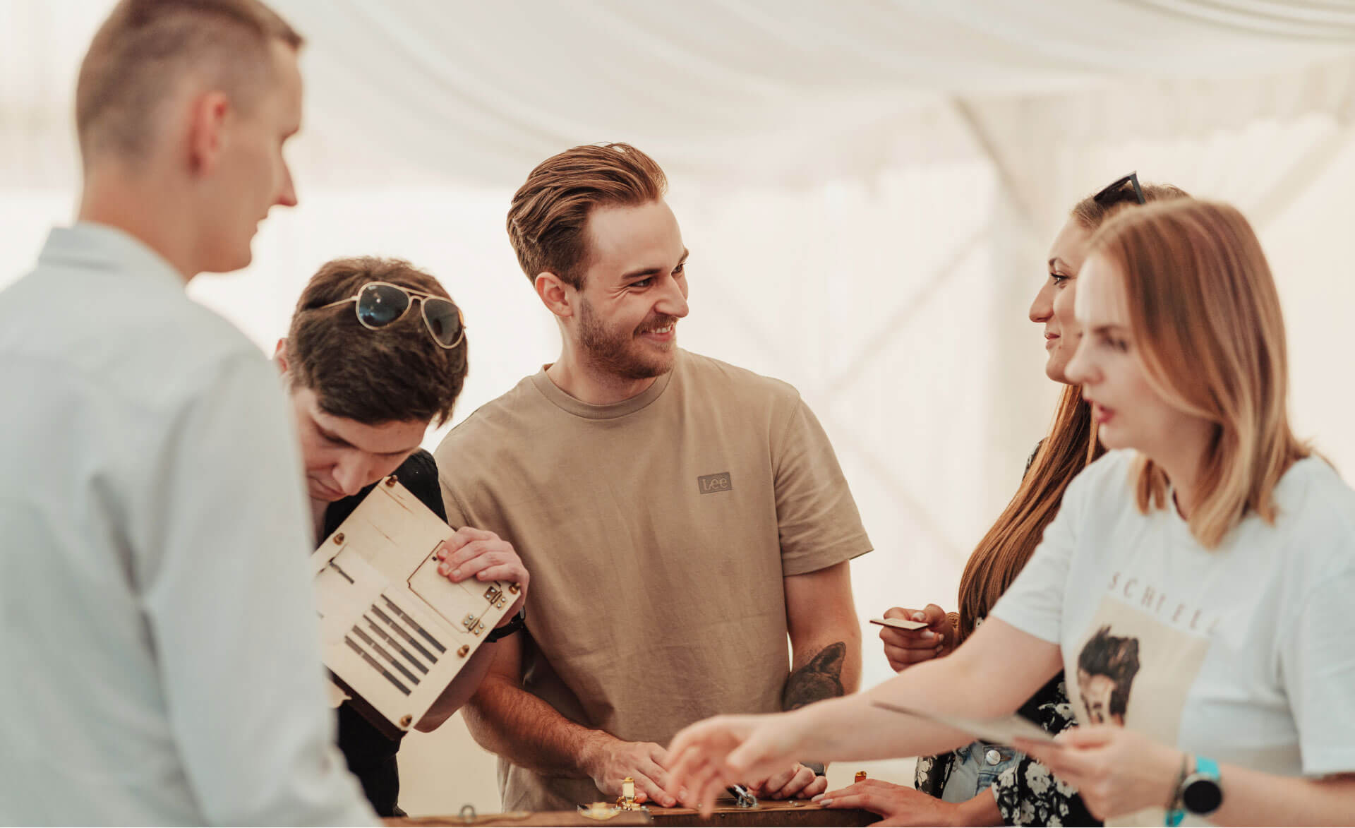 A close-up of five people, talking and smiling.