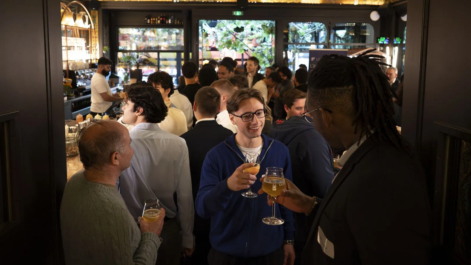 Members talk, drinks in hand, during an evening in Paris