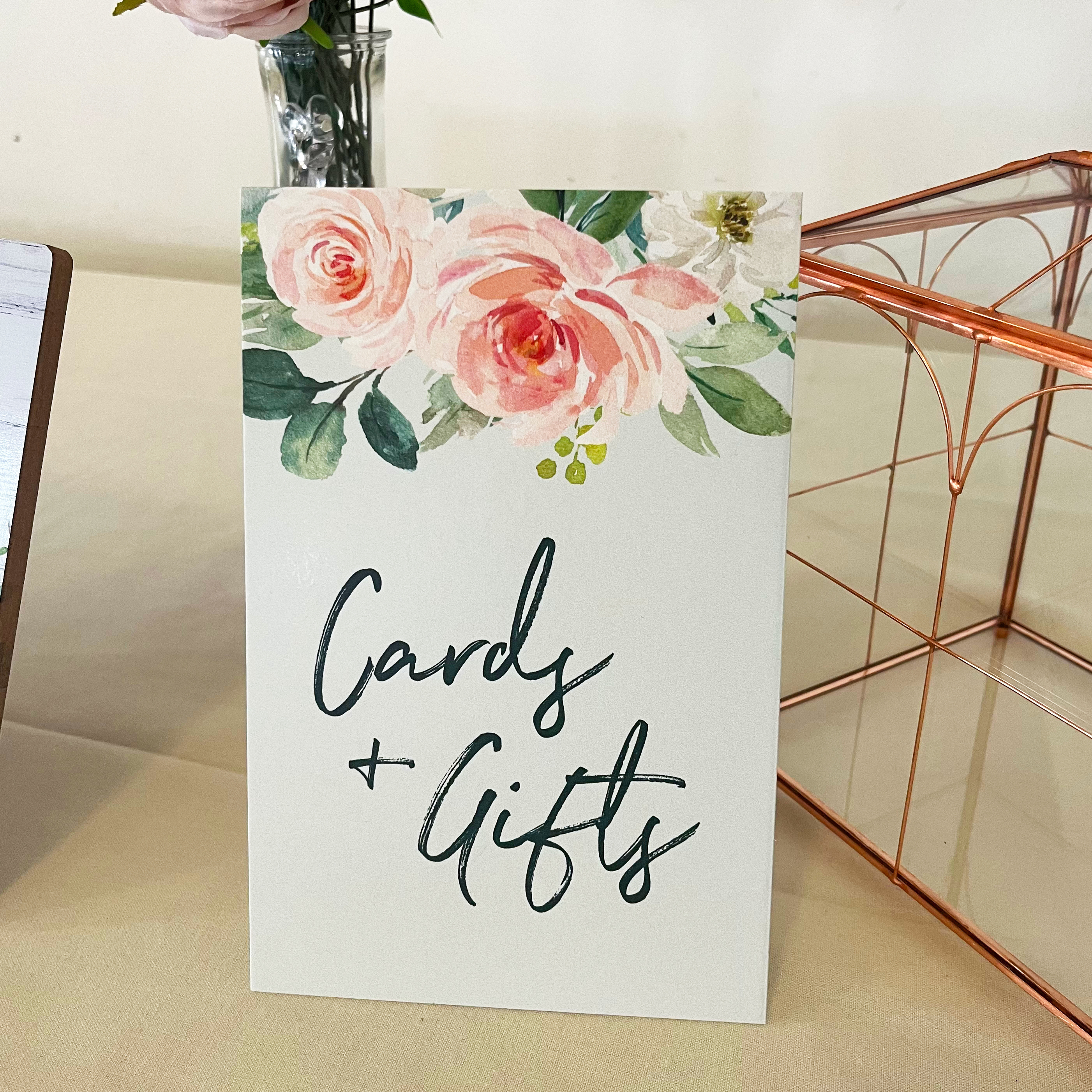Photo of the cards and gifts sign. Features watercolor flowers at the top and text that reads, "Cards and gifts"